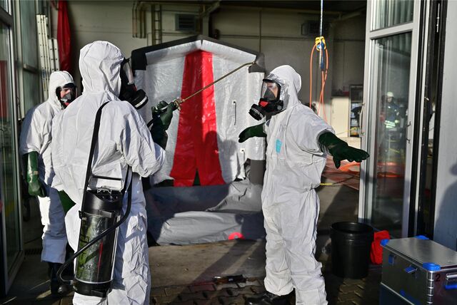 Feuerwehrkräfte in Schutzanzügen.