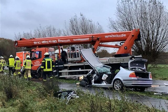 Unfall-Szene mit Hebebühnen-Lkw und zerstörtem Pkw.