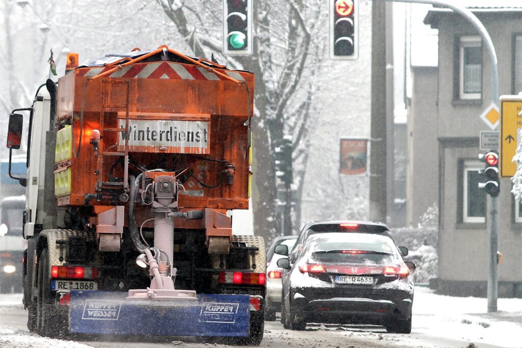 Ein Wagen des Winterdienstes auf einer verschneiten Straße in Recklinghausen.