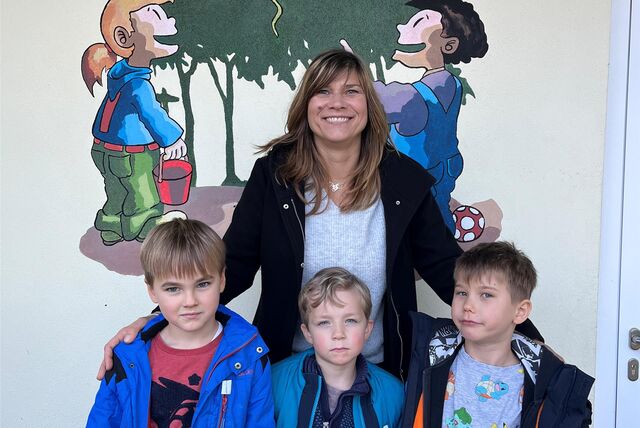 Kita-Mutter Patrycja Hombitzer steht mit den Vorschulkindern Valentin, Matteo und John vor der Eingangstür der Kita am Wald in Castrop-Rauxel.