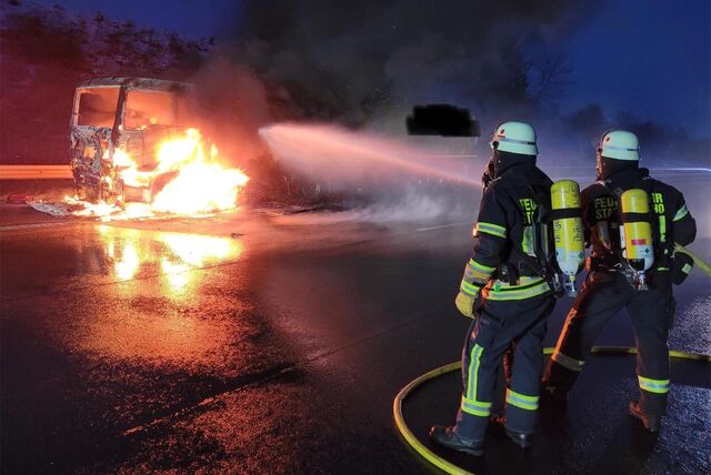 Zwei Feuerwehrleute löschen einen brennenden Tanklaster auf der A2 zwischen Vlotho und Herford.