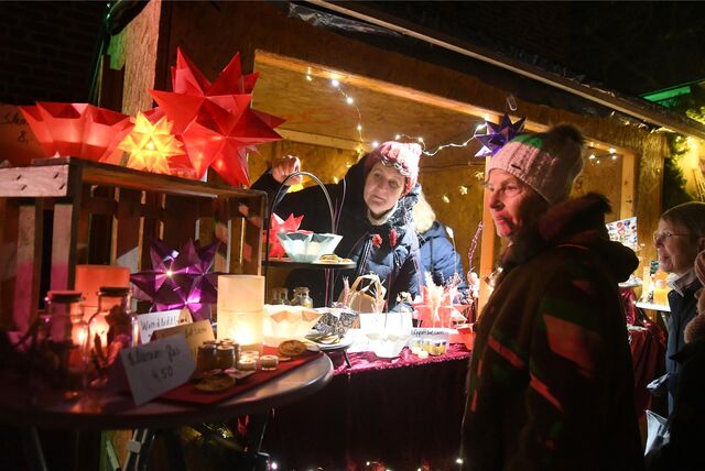 Eine Ausstellerin beim Adventsdorf an der Ickerner Christuskirche im Austausch mit potenziellen Kundinnen.