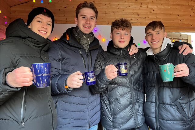 Vier Jungs im Glühwein-Stand.