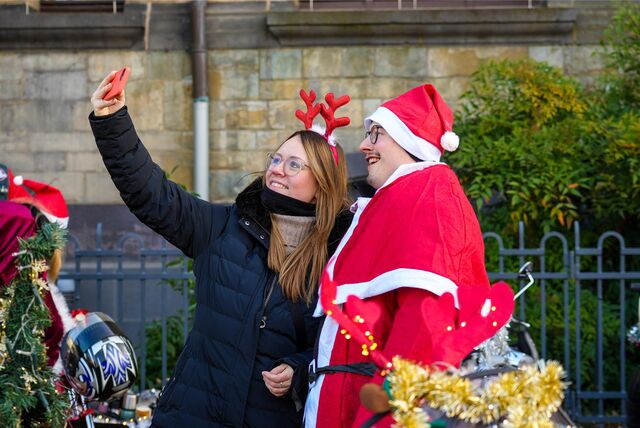 Eine Frau macht ein Selfie mit einem als Weihnachtsmann verkleideten Herrn auf dem Rathausplatz in Recklinghausen.