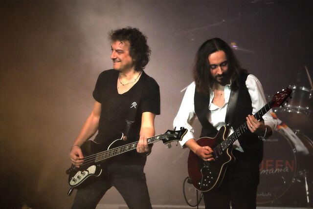 Zwei Männer spielen beim Live-Rockkonzert Foever Queen auf schwarzen E-Gitarren in schwarzer Kleidung.