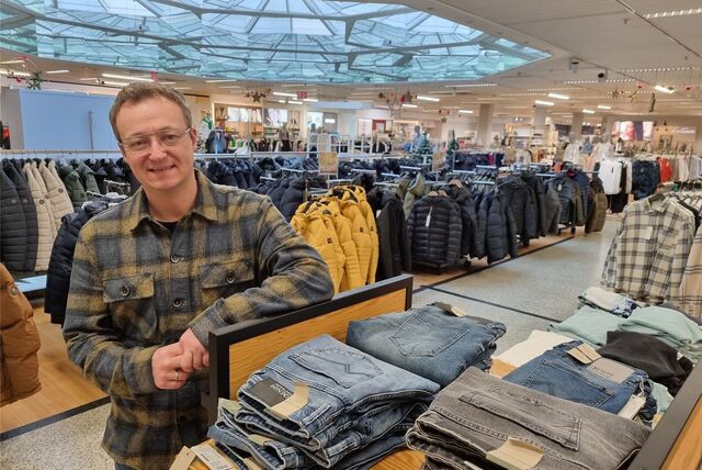Ein Mann steht an einem Kleiderständer