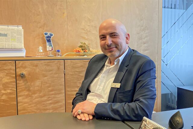 Volksbankmitarbeiter Ralf Schulz sitzt an einem Tisch in der Volksbankfiliale in Datteln.