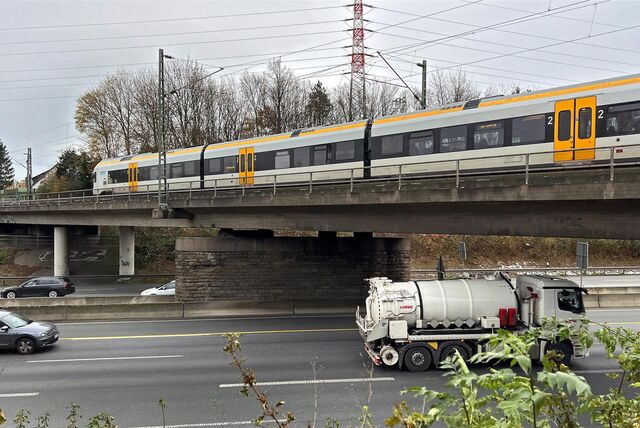 Ein Zug fährt über eine Eisenbahnbrücke über der Autobahn 1 in Unna.
