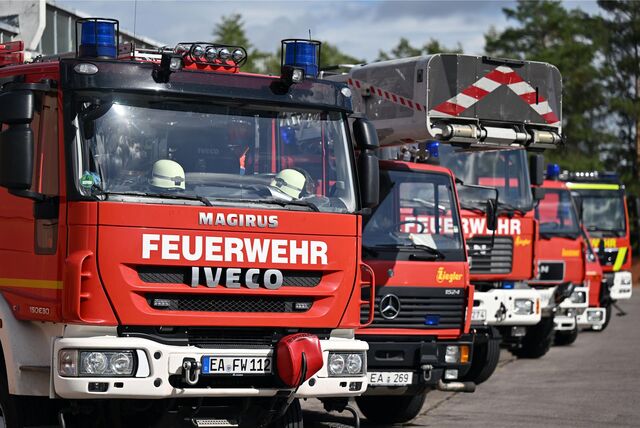 Mehrere Feuerwehrautos stehen nebeneinander in einer Reihe.