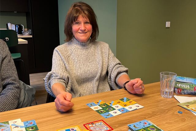 Tina Kraft spielt ein Legespiel und lächelt in die Kamera.