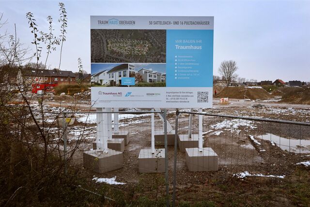 Mit einer großen Plakatwand wirbt die Traumhaus-AG am einstigen Erdbeerfeld für Häuser im Neubaugebiet.