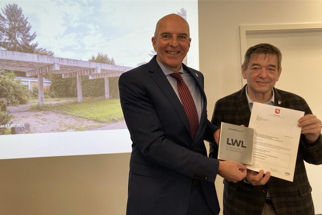 Vor einer Projektion von Marschall 66 übergibt LWL-Direktor Dr. Georg Lunemann den Förderbescheid über 400.000 Euro für das Kulturprojekt.