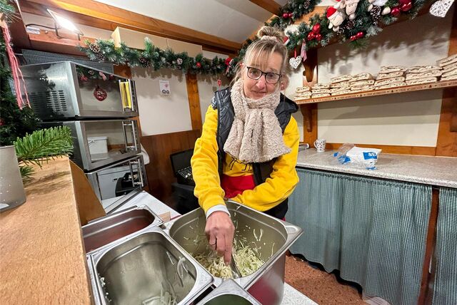 Heidrun Keiner steht in ihrer Bude auf dem Weihnachtsmarkt in Recklinghausen und bereitet Krautsalat zu.