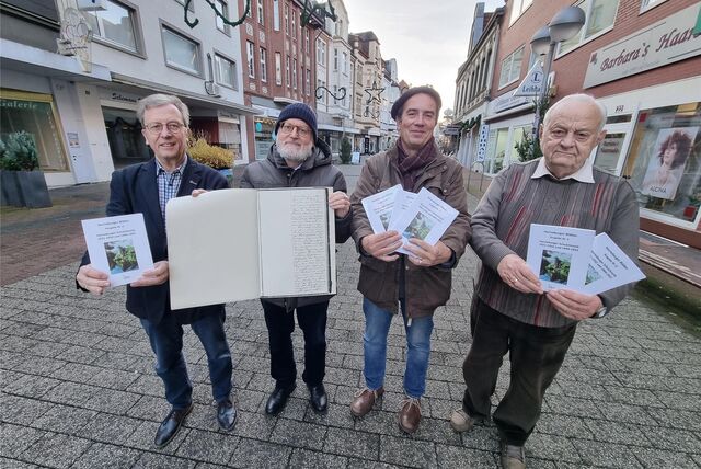 Vier Männer präsentieren Bücher.