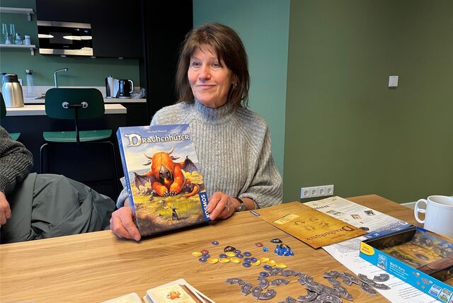 Tina Kraft hält das Spiel Drachenhüter in der Hand.