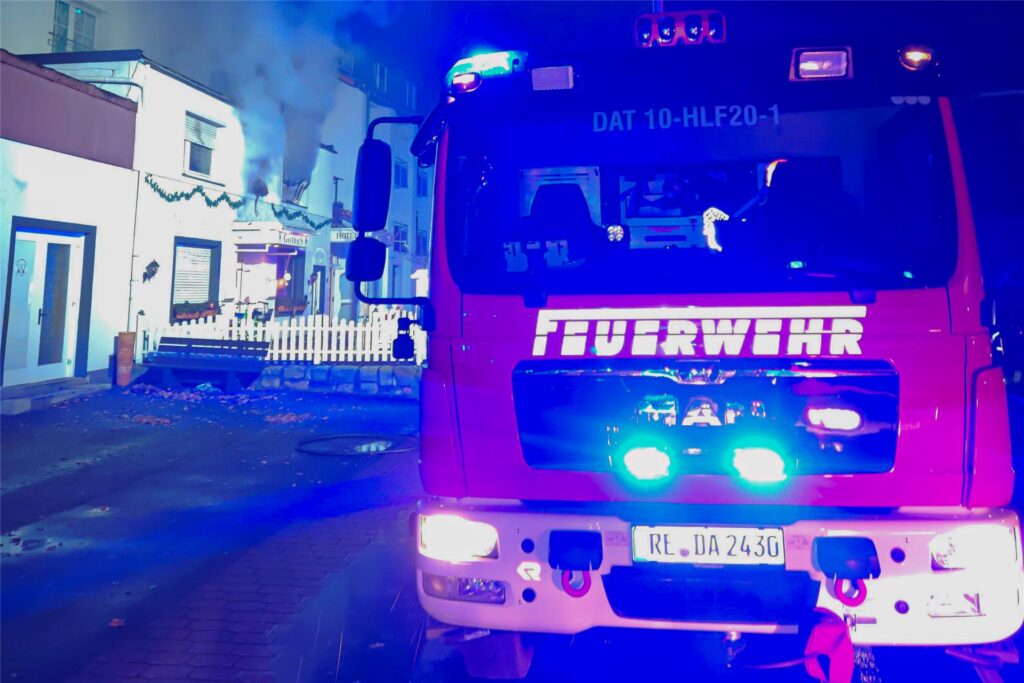 Links im Bild ist ein ehemaliges Hotel in Datteln zu sehen. Aus den Fenstern steigt Rauch auf. Rechts im Bild ist ein Feuerwehrfahrzeug zu sehen. Links im Bild ist ein ehemaliges Hotel in Datteln zu sehen. Aus den Fenstern steigt Rauch auf. Rechts im Bild ist ein Feuerwehrfahrzeug zu sehen.