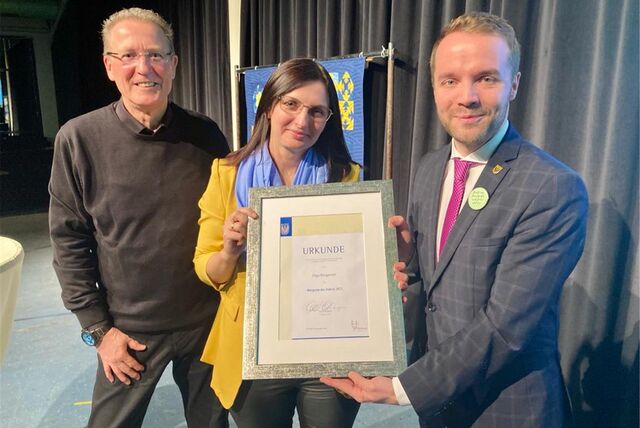 Bürgermeister Marcel Mittelbach überreicht die Urkunde zur Bürgerin des Jahres 2022 an Olga Rittgerott. Links daneben Laudator Peter Hirsch.