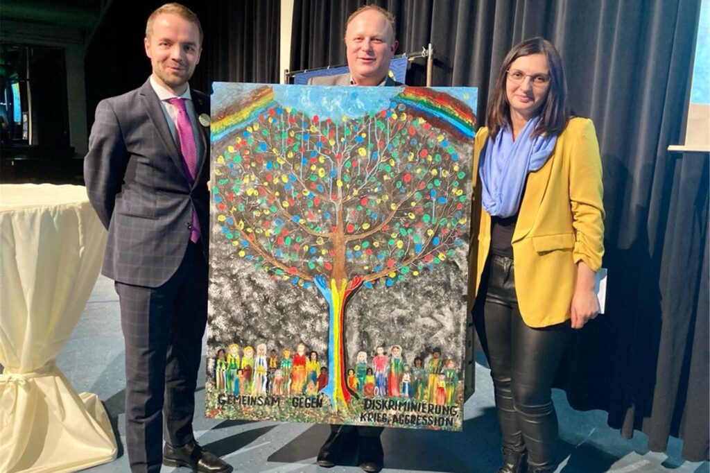 Das Bild eines Baumes überreichen Olga und Christian Rittgerott als Dank der ukrainischen Community an Bürgermeister Marcel Mittelbach.