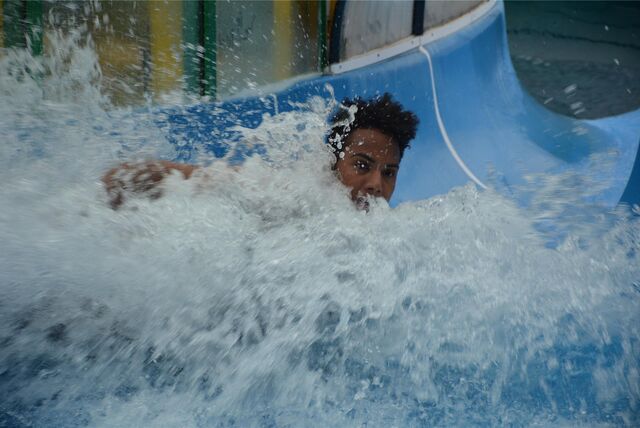 Ein Schwimmer rutscht ins Wasserbecken.