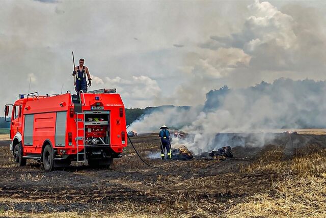 Ein Einsatzfahrzeug der Dattelner Feuerwehr steht auf einem brennenden Feld.