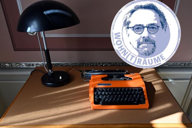 Ein Schreibtisch mit Leuchte und Schreibmaschine.