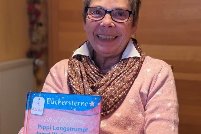 Lesepatin Gabriele Monitz mit einem Erstlesebuch von „Pippi Langstrumpf“ in der Hand.