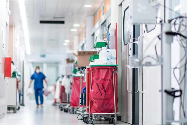 Ein Krankenhaus-Mitarbeiter läuft mit Maske über den Flur