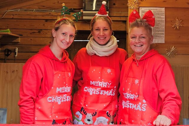 Drei Frauen an einem Stand auf dem Weihnachtsmarkt.