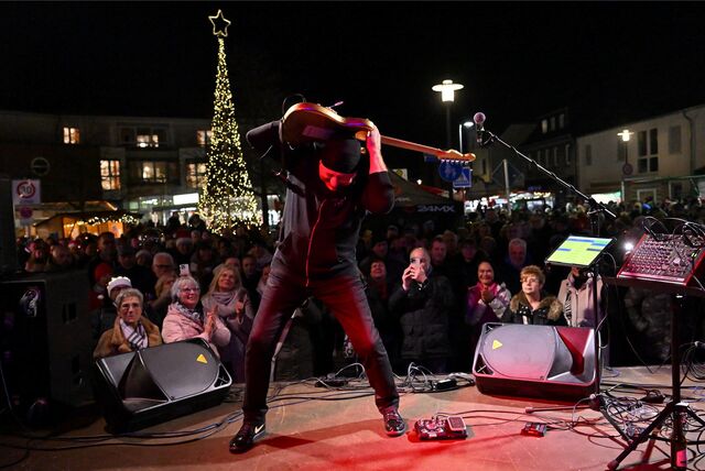 Ein Mann spielt auf seinem Rücken Gitarre.