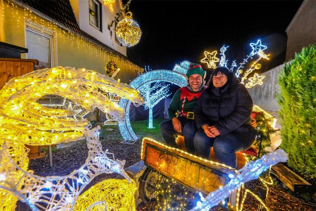 Tanja und Michael Klein sitzen in einer erleuchteten Kutsche an ihrem Weihnachtshaus in Recklinghausen.
