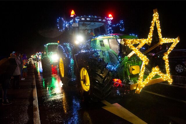 Ein Trecker ist mit Lichterketten behangen und vorn mit einem großen Stern geschmückt.