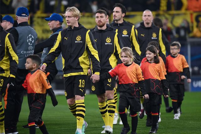 BVB-Spieler betreten mit Einlaufkindern an der Hand den Rasen des Signal Iduna Parks.