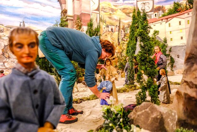 Aufbau der Riesen-Weihnachtskrippe in Stuckenbusch. Eine der Helferinnen steht in der Szene und platziert Figuren.