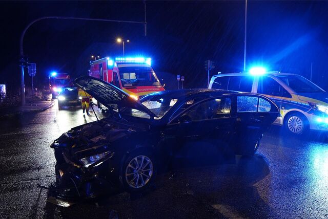 Die Feuerwehr ist im Einsatz bei einem Unfall auf der B235 an der Kreuzung Grutholzallee. Ein Auto steht mit geöffneter Motorhaube auf der Straße.