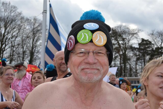 Ein Mann mit einer Mütze, an der einige Sticker befestigt sind, blickt in die Kamera.