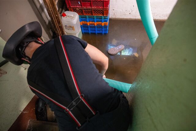 Feuerwehrmann pumpt Wasser aus einem Keller