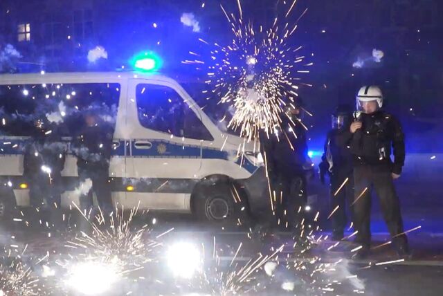 Polizeibeamte stehen hinter explodierendem Feuerwerk.