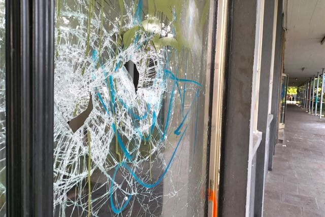 Auf dem Archivfoto ist eine bekritzelte Fensterscheibe zu sehen, die Einbrecher im Mai 2023 an der Realschule kaputt schlugen.