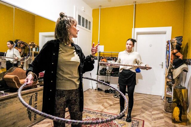Zwei Frauen mit Hula-Hoop-Reifen stehen vor einem Spiegel.
