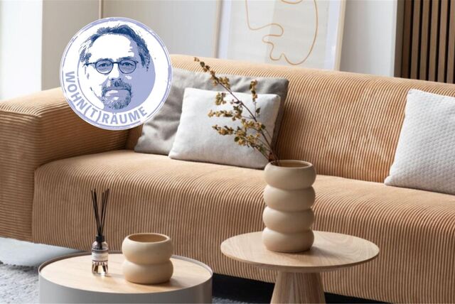 Ein Cordsofa in Beige mit Beistelltischen und Deko.
