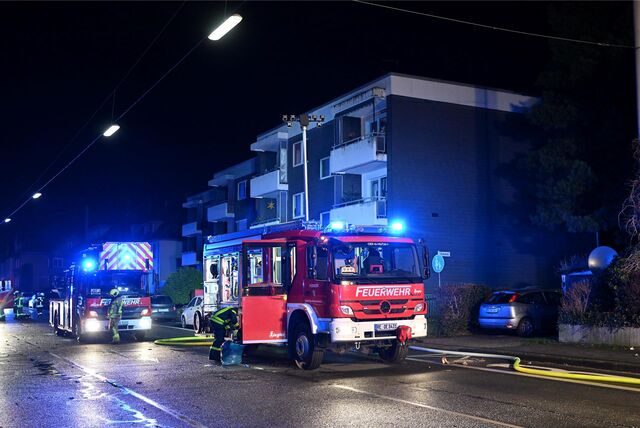 Einsatzfahrzeuge der Feuerwehr Oer-Erkenschwick stehen vor einem Mehrfamilienhaus.