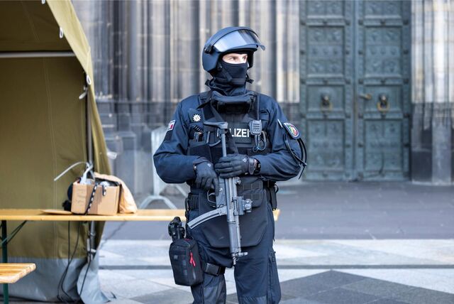 Ein Polizist steht vor dem Kölner Dom.