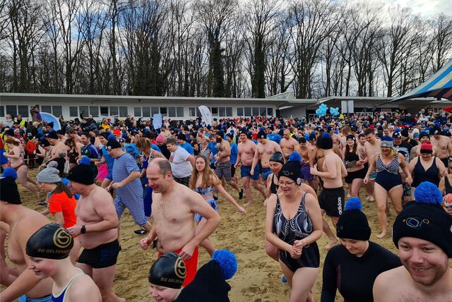 Schwimmer rennen über den Strand zum Stausee.