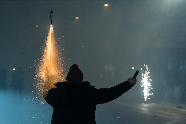 Mann hält Feuerwerk in der hand.