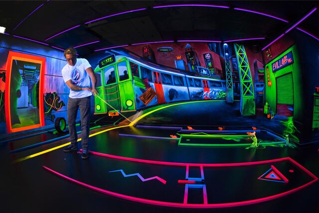Ein Mann spielt Schwarzlicht-Minigolf in Hagen (NRW).