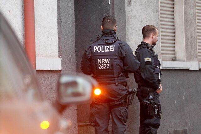 Zwei Polizisten stehen an einem Hauseingang