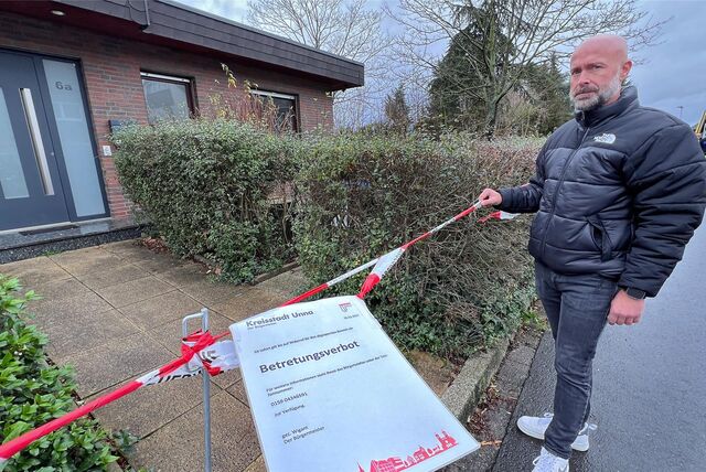 Alexander Krawczyk steht vor seinem Haus in Unna. Ein Flatterband und ein von der Stadt verhängtes Betretungsverbot verhindern ihm den Zugang zu seinem eigenen Haus.