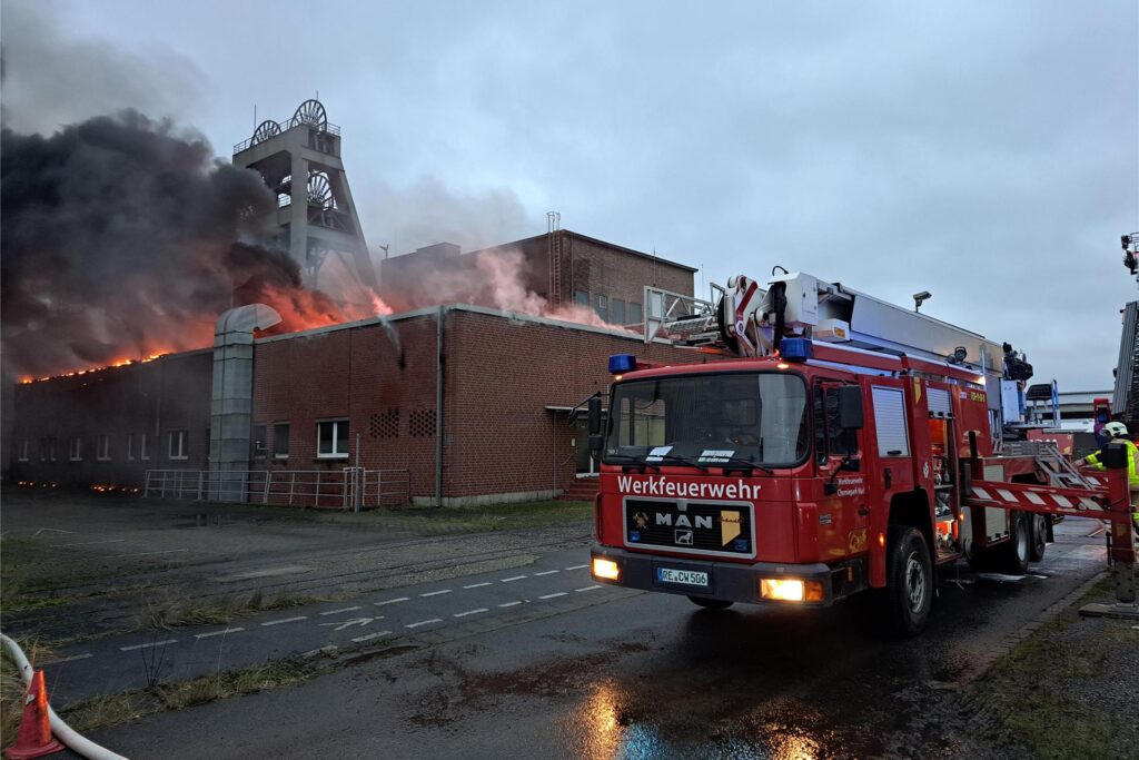 Ein Einsatzwagen der Feuerwehr steht vor einem brennenden Gebäude auf dem Gelände der ehemaligen Zeche Auguste Victoria (AV) in Marl. Ein Einsatzwagen der Feuerwehr steht vor einem brennenden Gebäude auf dem Gelände der ehemaligen Zeche Auguste Victoria (AV) in Marl.