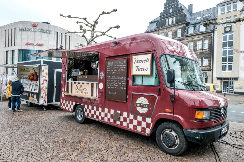 Zwei Foodtrucks stehen auf dem Rathausplatz in Recklinghausen, im Hintergrund ist das Palais Vest Zwei Foodtrucks stehen auf dem Rathausplatz in Recklinghausen, im Hintergrund ist das Palais Vest