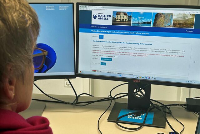 Frau sitzt vor einem Monitor, der das Serviceportal der Stadt Haltern am See zeigt.
